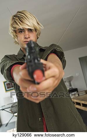 Teenage boy aiming handgun View Large Photo Image Stock Photograph - Teenage boy aiming handgun. Fotosearch