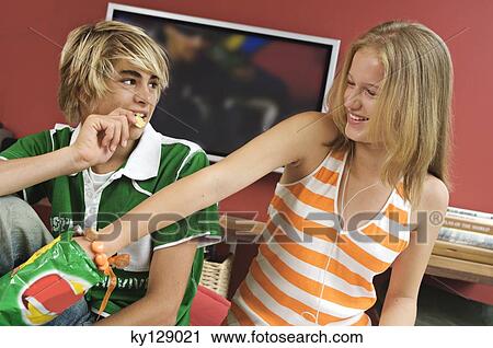 Teenage boy and girl eating crisps View Large Photo Image Stock Image - Teenage boy and girl eating crisps. Fotosearch