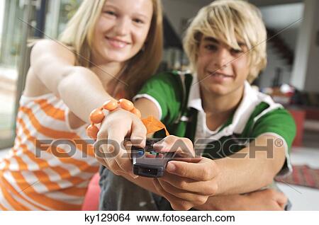Teenage boy and girl using remote control View Large Photo Image Picture - Teenage boy and girl using remote control. Fotosearch