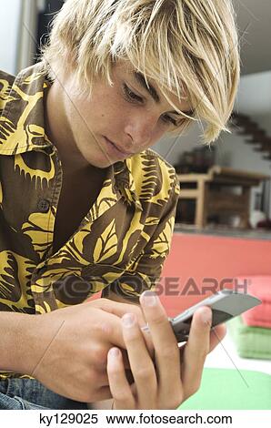 Stock Photography - Teenage boy using mobile phone. Fotosearch