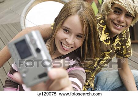 Teenage girl and boy photographing themselves View Large Photo Image Stock Photography - Teenage girl and boy photographing themselves. Fotosearch