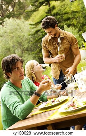 2 men and a woman sitting at garden table View Large Photo Image Stock Photo - 2 men and a woman sitting at garden table. Fotosearch
