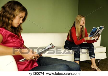 2 women reading on sofa View Large Photo Image Picture - 2 women reading on sofa. Fotosearch