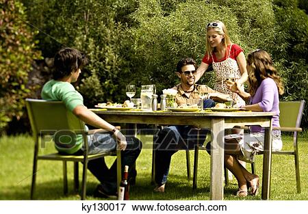 2 young couples sitting at garden table View Large Photo Image Stock Photo - 2 young couples sitting at garden table. Fotosearch