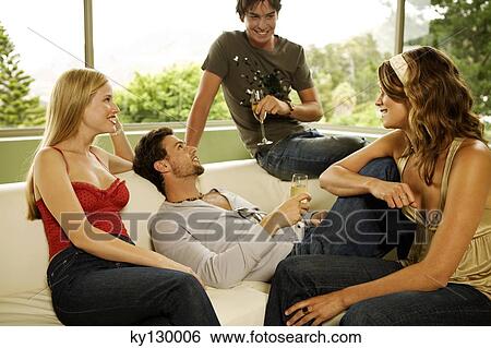 2 young smiling couples drinking champagne, sitting in sofa View Large Photo Image Stock Photograph - 2 young smiling couples drinking champagne, sitting in sofa. Fotosearch