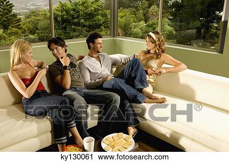 2 young smiling couples talking, sitting on sofa View Large Photo Image Stock Image - 2 young smiling couples talking, sitting on sofa. Fotosearch