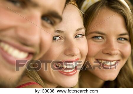 2 young women and a man smiling for the camera View Large Photo Image Stock Photograph - 2 young women and a man smiling for the camera. Fotosearch