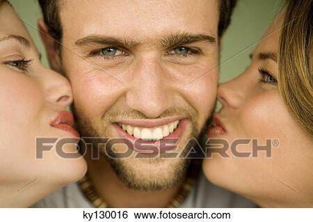 2 young women kissing smiling man View Large Photo Image Stock Photograph - 2 young women kissing smiling man. Fotosearch