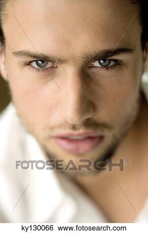 Portrait of a young man looking at the camera View Large Photo Image Stock Photograph - Portrait of a young man looking at the camera. Fotosearch