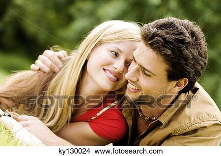 Portrait of a young smiling couple embracing, outdoors View Large Photo Image Picture - Portrait of a young smiling couple embracing, outdoors. Fotosearch