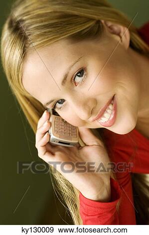 Portrait of a young smiling woman, using mobile phone View Large Photo Image Stock Photo - Portrait of a young smiling woman, using mobile phone. Fotosearch