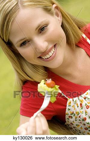 Portrait of a young smiling woman eating salad, outdoors View Large Photo Image Stock Photograph - Portrait of a young smiling woman eating salad, outdoors. Fotosearch