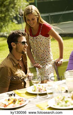 Young smiling couple at garden table View Large Photo Image Stock Photograph - Young smiling couple at garden table. Fotosearch