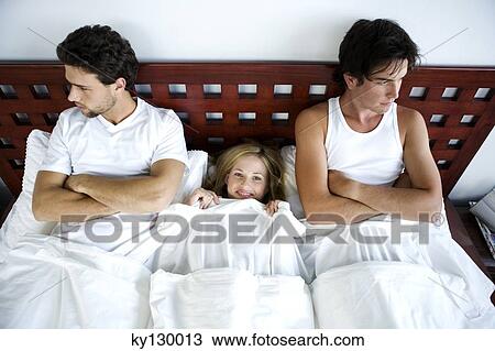 Young smiling woman in bed between 2 men, arms crossed View Large Photo Image Stock Image - Young smiling woman in bed between 2 men, arms crossed. Fotosearch
