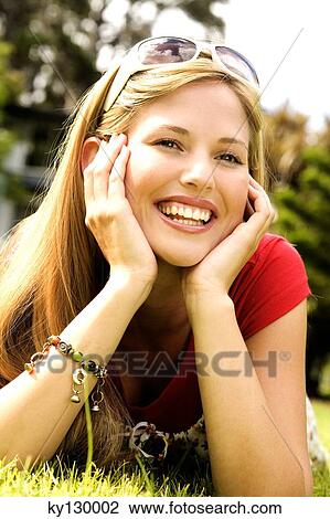 Young smiling woman lying on grass View Large Photo Image Stock Image - Young smiling woman lying on grass. Fotosearch