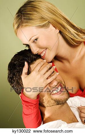 Young smiling woman with hand over man's eyes View Large Photo Image Stock Image - Young smiling woman with hand over man's eyes. Fotosearch