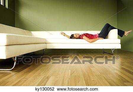 Young woman lying on a sofa View Large Photo Image Stock Image - Young woman lying on a sofa. Fotosearch