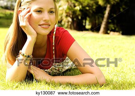 Stock Photo - Young woman lying on grass. Fotosearch