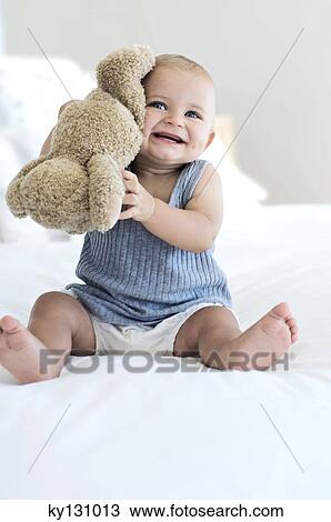 Baby sitting with teddy bear, indoors View Large Photo Image Stock Image - Baby sitting with teddy bear, indoors. Fotosearch