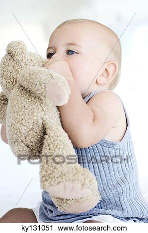 Baby sitting with teddy bear, indoors View Large Photo Image Stock Image - Baby sitting with teddy bear, indoors. Fotosearch