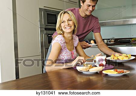 Couple in a kitchen, lunch, indoors View Large Photo Image Stock Image - Couple in a kitchen, lunch, indoors. Fotosearch