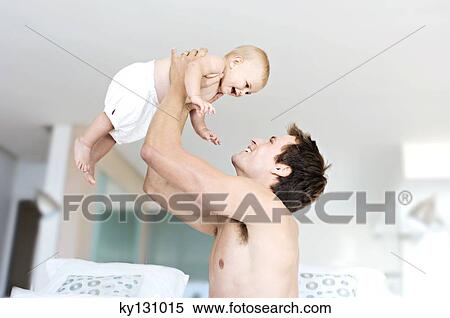 Father and baby playing, man lifting his son, indoors View Large Photo Image Stock Photography - Father and baby playing, man lifting his son, indoors. Fotosearch