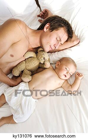 Stock Photograph - Father and baby sleeping, view from above, indoors. Fotosearch