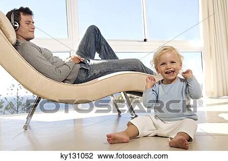 Father and little girl in living room, man listening to music, indoors View Large Photo Image Stock Image - Father and little girl in living room, man listening to music, indoors. Fotosearch