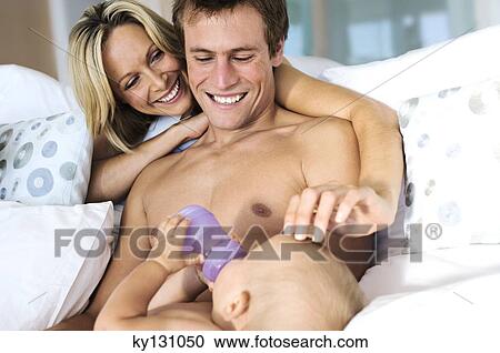 Father and mother looking at baby feeding, indoors View Large Photo Image Stock Image - Father and mother looking at baby feeding, indoors. Fotosearch