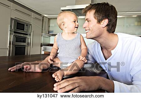 Father and son in kitchen, indoors View Large Photo Image Stock Photo - Father and son in kitchen, indoors. Fotosearch