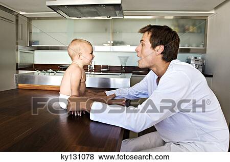 Father and son in kitchen, indoors View Large Photo Image Stock Photo - Father and son in kitchen, indoors. Fotosearch
