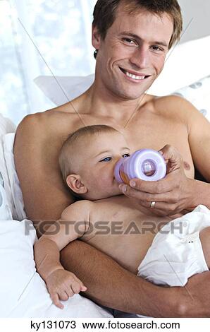 Father feeding his baby, indoors View Large Photo Image Stock Image - Father feeding his baby, indoors. Fotosearch