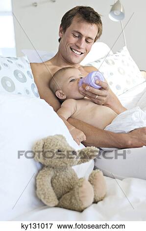 Father feeding his baby, indoors View Large Photo Image Stock Photo - Father feeding his baby, indoors. Fotosearch