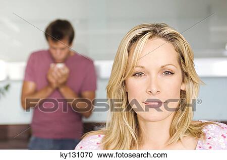 Portrait of a young thoughtful woman, man in background, indoors View Large Photo Image Stock Image - Portrait of a young thoughtful woman, man in background, indoors. Fotosearch