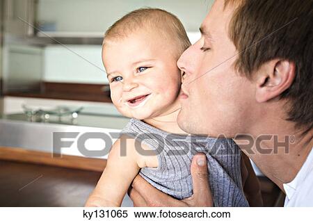 Portrait of father and son in kitchen, man kissing his baby, indoors View Large Photo Image Stock Photography - Portrait of father and son in kitchen, man kissing his baby, indoors. Fotosearch