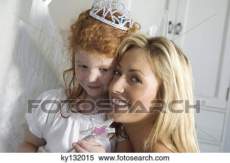 Christmas day, portrait of a mother and daughter smiling, looking at the camera, indoors View Large Photo Image Stock Photography - Christmas day, portrait of a mother and daughter smiling, looking at the camera, indoors. Fotosearch