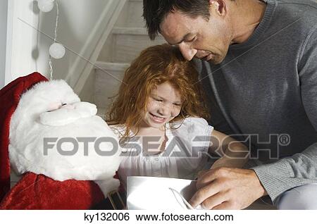 Father and ldaughter opening Christmas presents, indoors View Large Photo Image Stock Photograph - Father and ldaughter opening Christmas presents, indoors. Fotosearch