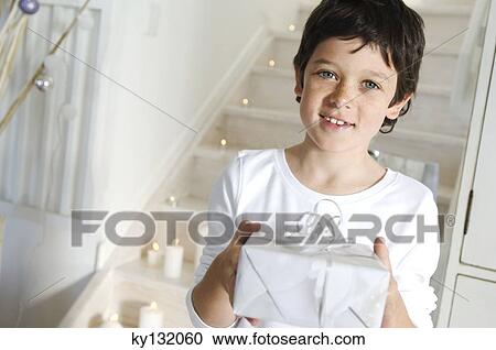Little boy offering a Christmas present, indoors View Large Photo Image Stock Image - Little boy offering a Christmas present, indoors. Fotosearch