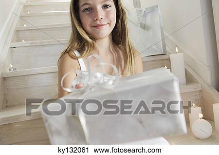 Little girl holding a Christmas present, indoors View Large Photo Image Stock Image - Little girl holding a Christmas present, indoors. Fotosearch