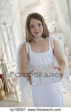 Little girl holding a Christmas present, indoors View Large Photo Image Stock Photo - Little girl holding a Christmas present, indoors. Fotosearch