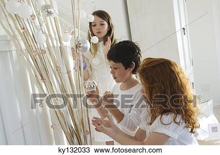Three children decorating branches with Christmas balls, indoors View Large Photo Image Stock Image - Three children decorating branches with Christmas balls, indoors. Fotosearch