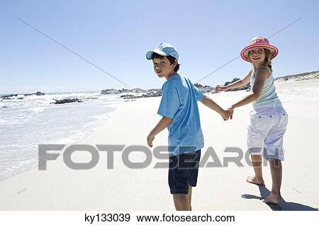 Brother and sister walking on the beach, outdoors View Large Photo Image Stock Photo - Brother and sister walking on the beach, outdoors. Fotosearch