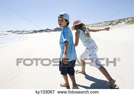 Brother and sister walking on the beach, outdoors View Large Photo Image Stock Photo - Brother and sister walking on the beach, outdoors. Fotosearch