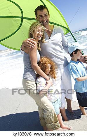 Couple and two children on the beach, outdoors View Large Photo Image Stock Photo - Couple and two children on the beach, outdoors. Fotosearch
