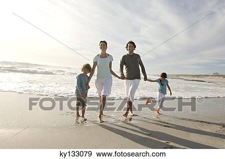 Couple, son and daughter walking on the beach, outdoors View Large Photo Image Stock Photo - Couple, son and daughter walking on the beach, outdoors. Fotosearch