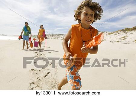 Parents and little boy walking on the beach, outdoors View Large Photo Image Stock Image - Parents and little boy walking on the beach, outdoors. Fotosearch