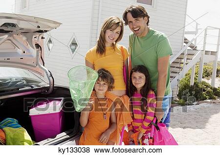 Parents and two children in front of a house, near their car, ready to go to the beach, outdoors View Large Photo Image Stock Photo - Parents and two children in front of a house, near their car, ready to go to the beach, outdoors. Fotosearch