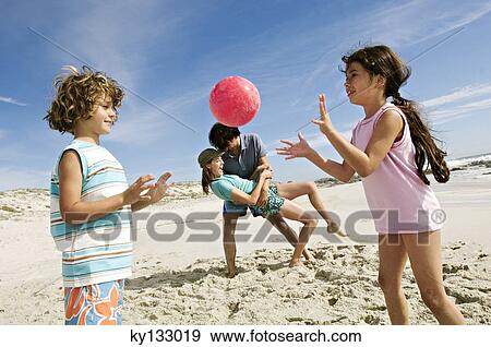 Parents and two children playing on the beach, outdoors View Large Photo Image Stock Photo - Parents and two children playing on the beach, outdoors. Fotosearch