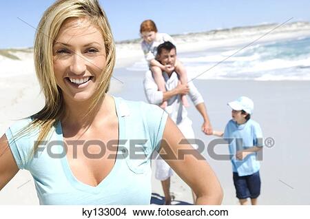 Parents and two children walking on the beach, woman in foreground, outdoors View Large Photo Image Picture - Parents and two children walking on the beach, woman in foreground, outdoors. Fotosearch