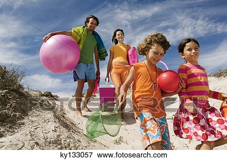 Parents and two children walking on the beach, outdoors View Large Photo Image Stock Photo - Parents and two children walking on the beach, outdoors. Fotosearch